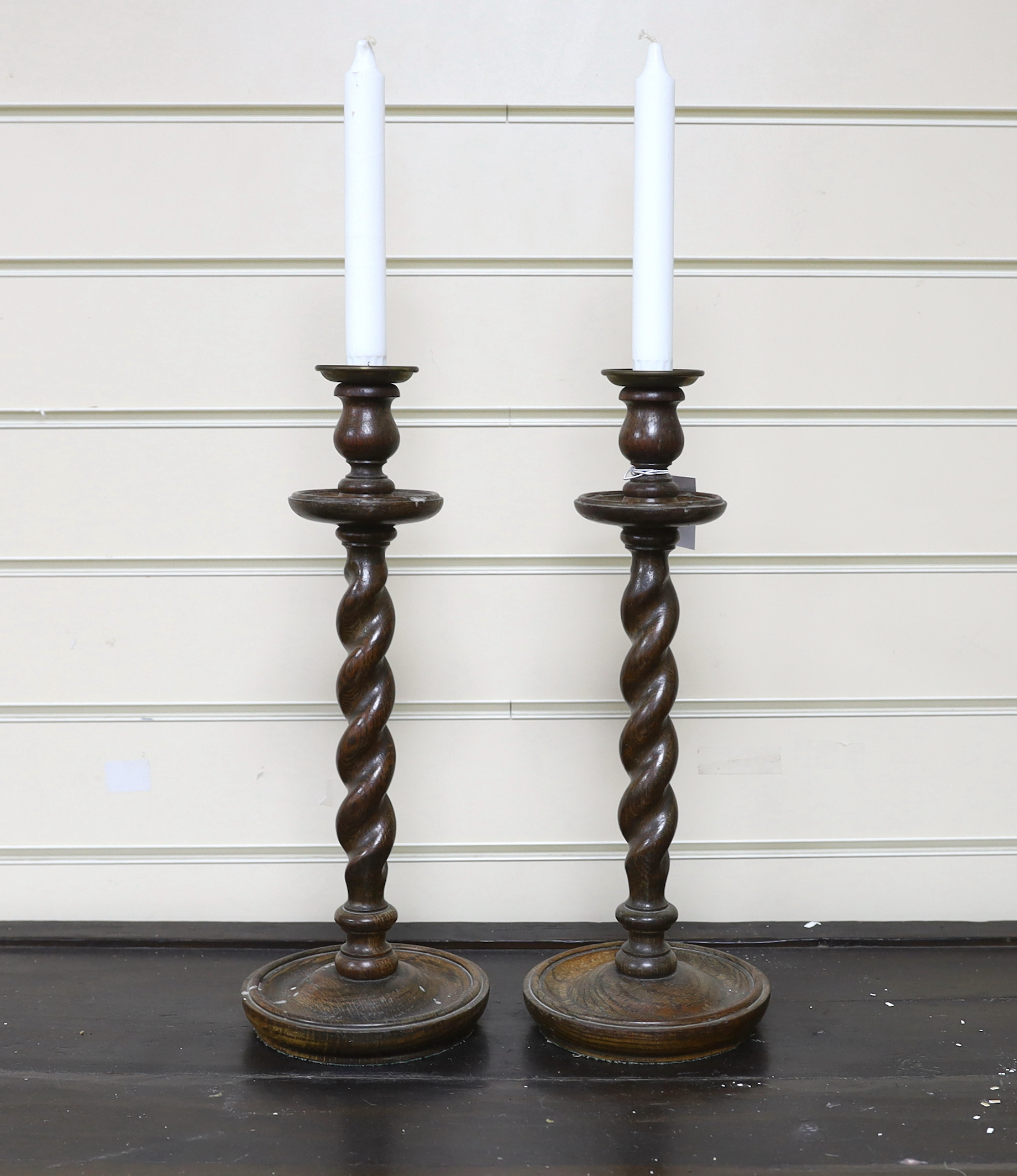 A pair of early 20th century spiral turned candlesticks with brass sconces, height 38cm